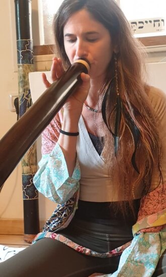 אישה מנגנת בדיג'רידו - סטודיו נשימה מעגלית - אייל עמית אישה מנגנת בדיג'רידו - סטודיו נשימה מעגלית - אייל עמית